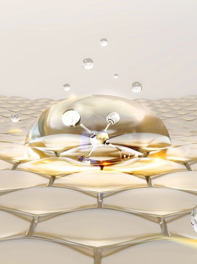 A reflective water droplet landing on a honeycomb-like surface.